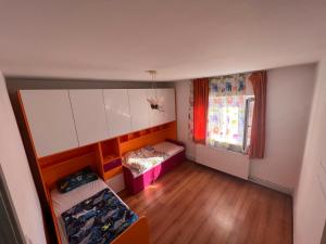 a small room with two beds and a window at L&L Apartment in Braşov