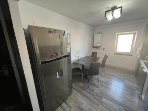 a kitchen with a stainless steel refrigerator and a table at L&L Apartment in Braşov