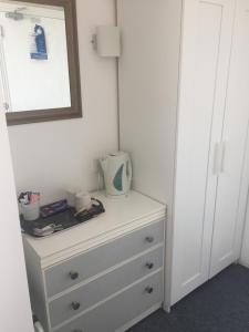 a white dresser with a mirror on top of it at Seaview Sanctuary in Eastbourne