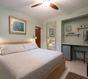 a bedroom with a bed and a ceiling fan at Casa Mia Guest House in Rincon