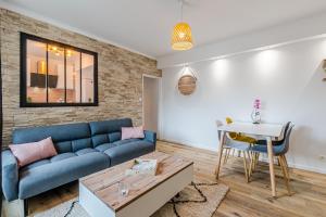 a living room with a blue couch and a table at Home Design Hayange in Hayange