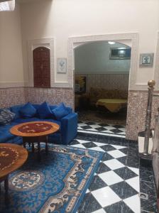 un salon avec un canapé bleu et des tables dans l'établissement Riad Qariya siyahiya, à Marrakech