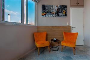 2 sillas naranjas y una mesa en una habitación en Noor, a KalamataStay Property, en Kalamata