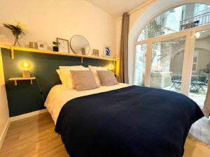 1 dormitorio con 1 cama grande y ventana grande en Le Patio - Rénové et Proche lac en Nantua