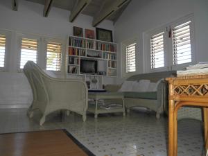 uma sala de estar com um sofá e uma televisão em Villa Romana em Freetown Village