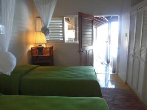 ein Schlafzimmer mit einem grünen Bett und einem Flur in der Unterkunft Villa Romana in Freetown Village