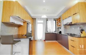 cocina grande con armarios de madera y encimera en Victory Villa Apartment Hotel, en Kigali