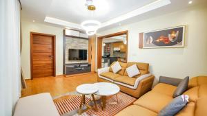 sala de estar con sofá y mesa en Victory Villa Apartment Hotel, en Kigali