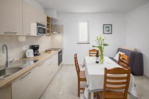 eine Küche mit einem Tisch und Stühlen in einer Küche in der Unterkunft Apartment Kazalac Green Oasis in Poreč