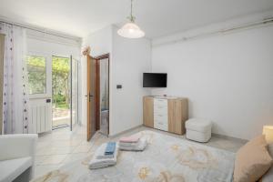 ein Wohnzimmer mit einem Bett, einem TV und einem Sofa in der Unterkunft Apartment Kazalac Green Oasis in Poreč