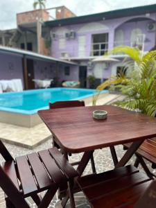 a wooden table and chairs next to a swimming pool at Residencial Napolitan in Manaus