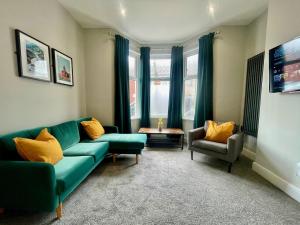 a living room with a couch and two chairs and a table at 3 Bedroom Spacious House in Cardiff in Cardiff