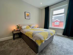 a bedroom with a bed and a window at 3 Bedroom Spacious House in Cardiff in Cardiff