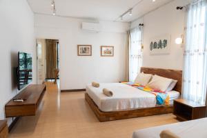Un dormitorio con una cama y una mesa. en Chiang Mai Mansion 2, en Chiang Mai