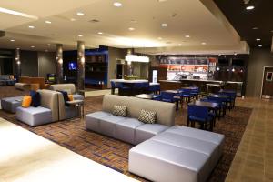 a lobby with couches and tables and a bar at Courtyard by Marriott Battle Creek in Battle Creek