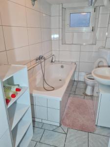 a bathroom with a tub and a toilet and a sink at Ramstein Wohnung in Ramstein-Miesenbach