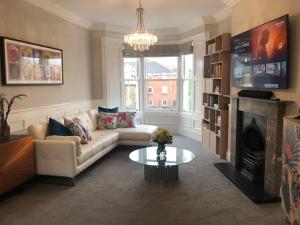 a living room with a couch and a fireplace at Stunning 2 bed apartment in Jesmond in High Heaton