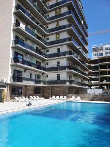 a building with a swimming pool in front of a building at Ayan Luxury By Complex Almar in Mamaia Sat/Năvodari