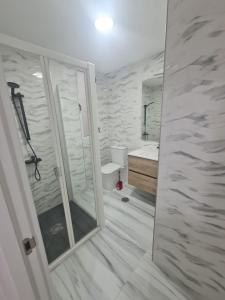 ein Bad mit einer Dusche, einem WC und einem Waschbecken in der Unterkunft Family House, CENTRO CIUDAD - 3 DORMITORIOS in Ceuta