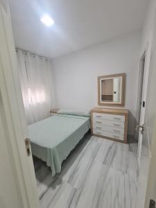 una camera con letto, cassettiera e specchio di Family House, CENTRO CIUDAD - 3 DORMITORIOS a Ceuta