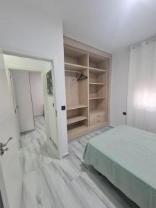 Camera bianca con letto e armadio di Family House, CENTRO CIUDAD - 3 DORMITORIOS a Ceuta