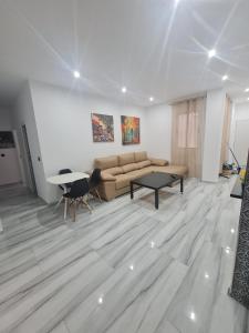 uma sala de estar com um sofá e uma mesa em Family House, CENTRO CIUDAD - 3 DORMITORIOS em Ceuta