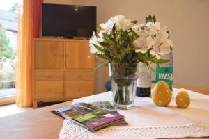 um vaso de flores e um livro sobre uma mesa em Adelheid Winkelmann em Hermannsburg