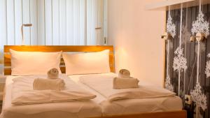a white bed with two towels on top of it at Frische Brise FeWo 07 03 in Cuxhaven +19 photos