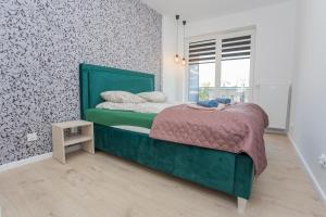 Un dormitorio con una cama verde y una ventana en Urban Jungle apartment Charlotte, en Białystok
