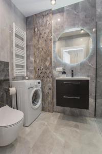 a bathroom with a washing machine and a mirror at Urban Jungle apartment Charlotte in Białystok