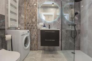 a bathroom with a sink and a washing machine at Urban Jungle apartment Charlotte in Białystok +8 photos