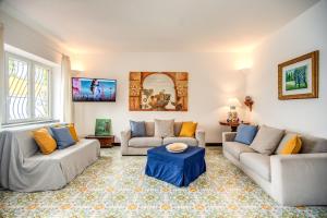 ein Wohnzimmer mit 2 Sofas und einem Tisch in der Unterkunft Villa Levante in Positano