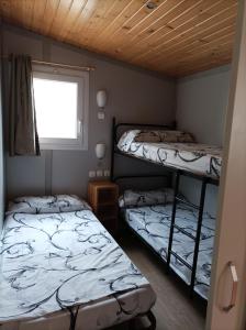 2 stapelbedden in een kamer met een raam bij La Masia BG parc in Sant Pere Pescador