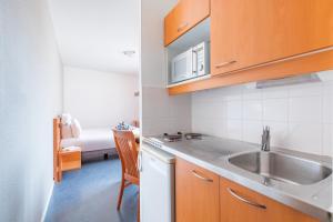 Kuchyň nebo kuchyňský kout v ubytování Appart’City Confort Lyon Gerland
