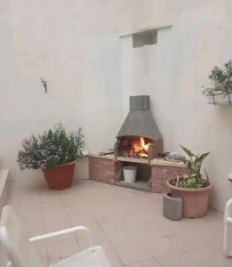 - une cuisine extérieure avec une cheminée dans une pièce ornée de plantes dans l'établissement The Valley Maisonette with private pool in M'scala, à Marsaskala