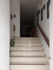 un escalier avec des escaliers blancs dans une maison dans l'établissement The Valley Maisonette with private pool in M'scala, à Marsaskala