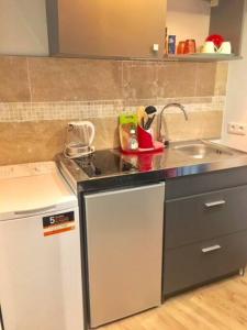 a small kitchen with a sink and a stove at Studio terrasse. A 50m de la plage Sablettes in Menton +4 photos