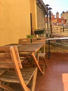 a wooden table and chairs sitting on top of a building at Studio terrasse. A 50m de la plage Sablettes in Menton