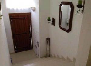 La salle de bains est pourvue d'une porte marron et d'un miroir. dans l'établissement The Valley Maisonette with private pool in M'scala, à Marsaskala