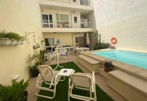 eine Terrasse mit Stühlen und einem Pool in der Unterkunft The Valley Maisonette with private pool in M'scala in Marsaskala