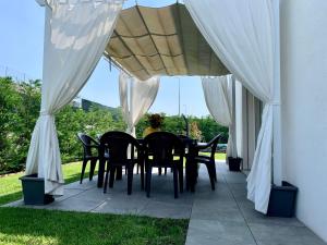 stół i krzesła pod baldachimem na patio w obiekcie Villa Carlotta w mieście Salionze