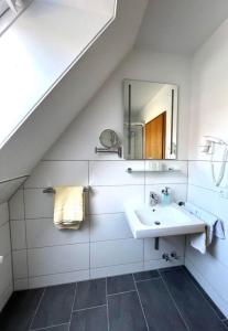 a white bathroom with a sink and a mirror at Appartementhaus Müller in Niendorf
