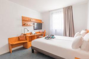 um quarto de hotel com uma cama e uma secretária em Appart’City Confort Lyon Gerland em Lyon