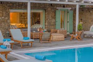 a patio with chairs and a swimming pool at Villa Mando in Super Paradise Beach