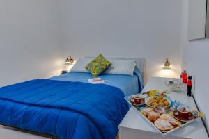 um quarto com uma cama azul e uma bandeja de comida em Matisé Home Relax em Sciacca