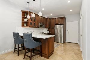 a kitchen with wooden cabinets and a kitchen island with chairs at 683 Just inside the gates of the Resort - Golf & Premier Fitness Guests Welcome in Encinitas