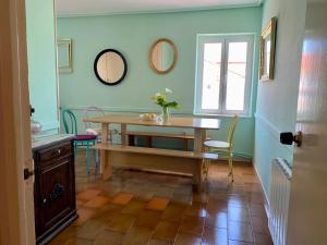 uma sala de jantar com uma mesa e dois espelhos em casa loopez Hostel em Laredo