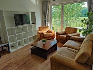 sala de estar con sofá, sillas y TV en Mieszkanie przy Błoniach baza wypadowa na Rower, en Rumia