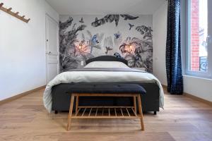 a bedroom with a bed and a wall with butterflies at Appart 2 personnes à 50m des commerces & mer in Barneville-Carteret