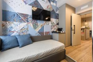 Cette chambre dispose d'un lit et d'un mur avec une télévision. dans l'établissement Castro Pretorio, à Rome